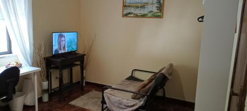 科英布拉Casa das Tílias的客厅配有椅子和电视