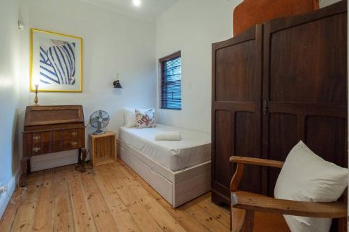 开普敦Snug Haven Cottage的一间卧室配有一张床,铺有木地板