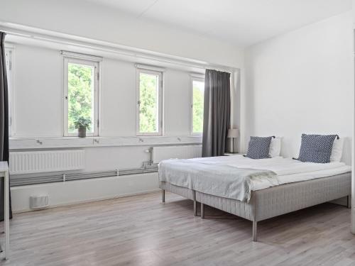 Norsborg斯拉格斯塔斯特兰德公寓式酒店的一间白色卧室,配有床和2个窗户