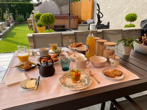 Cléry-Saint-AndréLe Clos du Q’hâtre的一张桌子,上面有早餐食品和饮料