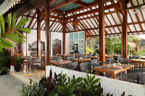 沙努尔Puri Tempo Doeloe Boutique Hotel的户外餐厅设有木桌和椅子