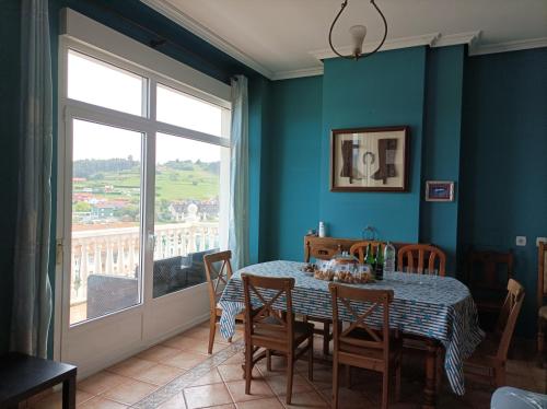NavecesLa Cariñosa的一间带桌椅和窗户的用餐室