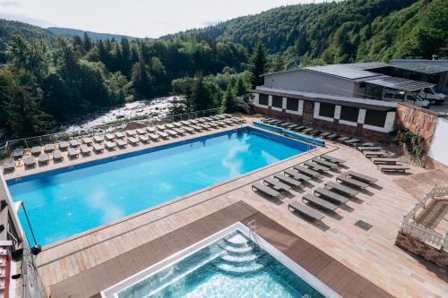 亚列姆切MORVA Premium Spa Resort的享有带椅子的游泳池和大楼的顶部景致