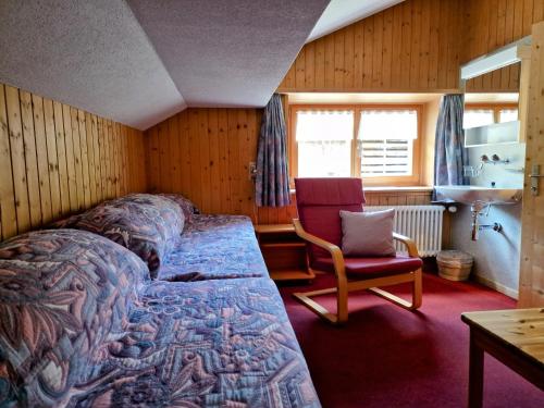 Glaris2 Zimmer Ferienwohnung Davos-Glaris的一间卧室,卧室内配有一张床和一把椅子
