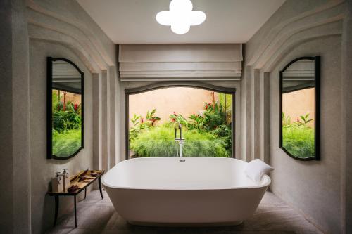 塔可克海滩Phulay Bay, A Ritz-Carlton Reserve的带浴缸的浴室和2个窗户