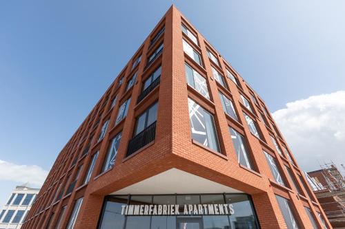 弗利辛恩Aparthotel Timmerfabriek Apartments I Kloeg Collection的红砖建筑,上面有标志