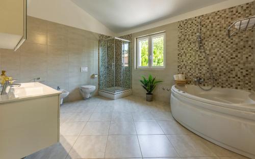 普拉Lotus Villas Resort的带浴缸、盥洗盆和卫生间的浴室