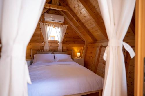 扎顿Dionis Zaton - Camping, Glamping, Holiday Houses & Rooms的小木屋内一间卧室,配有一张床