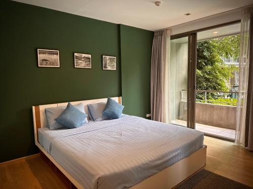 七岩班圣克兰姆公寓的一间卧室设有绿色的墙壁和一张带蓝色枕头的床。