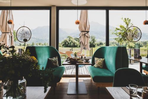 SatteinsTILL Naturhotel - Self-Check-In的一间配备有绿色椅子和桌子的用餐室