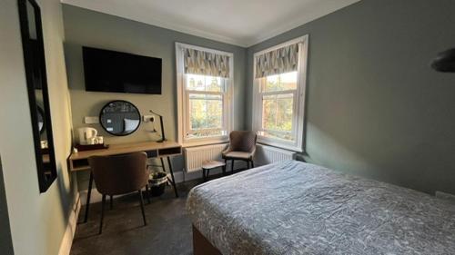 伦敦夏洛特宾馆的一间卧室配有一张床和一张带电脑的书桌