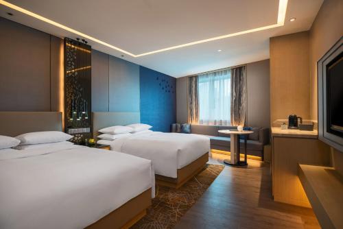 深圳深圳彭年万丽酒店的酒店客房设有两张床和电视。