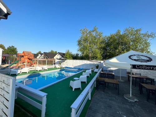 尤斯托尼莫斯基Domki letniskowe Layla的一个带桌椅和遮阳伞的游泳池