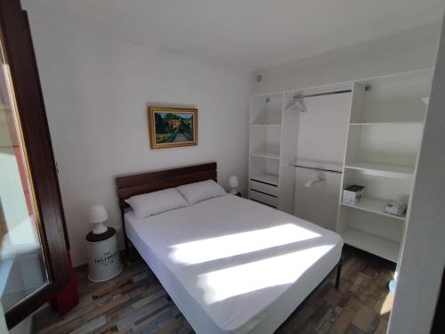 滨海萨纳里Sanary Paradise Port Climatisé的一间小卧室,配有白色的床和架子