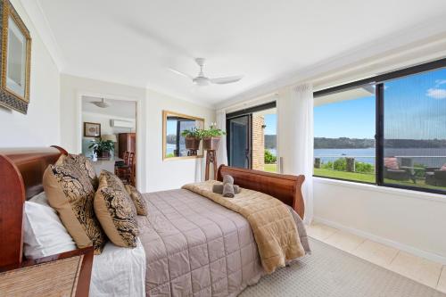 悉尼Waterfront on Manly Harbour的一间卧室设有一张床和一个大窗户