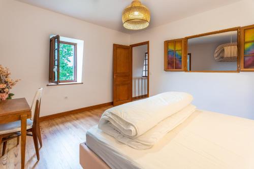 萨利耶德贝阿尔恩Lou Grit - Maison pour 10 avec piscine privée的一间卧室配有一张床、一张桌子和一个窗户。