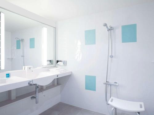 阿姆博斯诺沃特昂博瓦斯酒店的白色的浴室设有2个盥洗盆和淋浴。