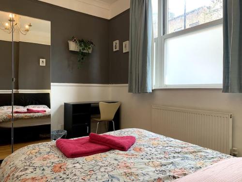 伦敦Keysan House 1的一间卧室配有一张带红色毛巾的床