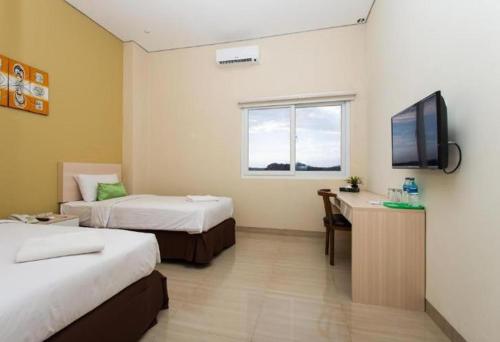 巴厘巴板Best Inn Balikpapan的酒店客房设有两张床和一台平面电视。