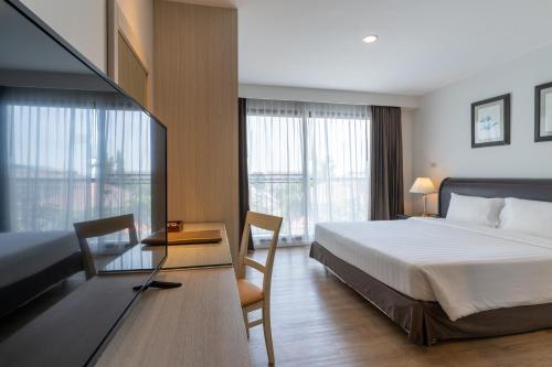 是拉差坎塔瑞海湾酒店是拉差服务式公寓的酒店客房设有一张床、一张书桌和窗户。