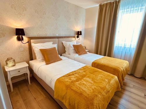 阿尔贝Le Royal Picardie的酒店客房设有两张床和窗户。