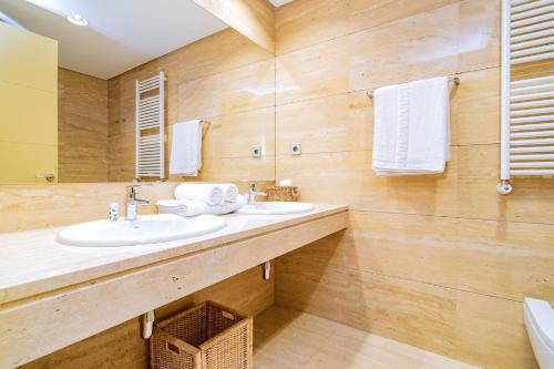 马德里Velazquez Suites的一间带两个盥洗盆和大镜子的浴室