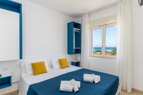 托雷桑塔萨宾娜Calanca Apulian Residence的卧室配有蓝色和白色的床和窗户。