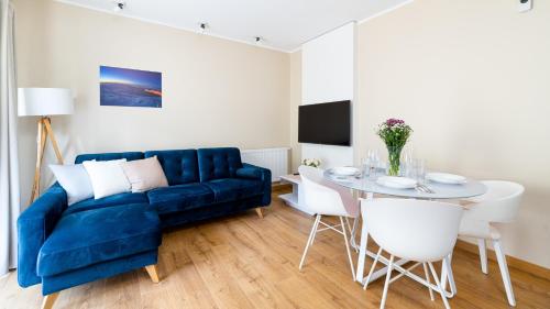 卡尔帕奇Apartamenty Sun & Snow Rezydencja Karkonoska的客厅配有蓝色的沙发和桌子