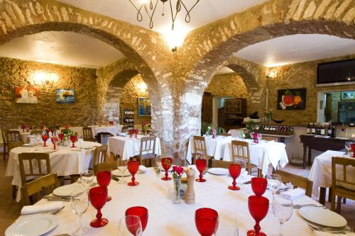 帕德内Hospedaria Moiras Encantadas的用餐室配有白色桌子和红葡萄酒杯
