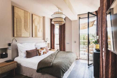 普罗旺斯艾克斯Les Lodges Sainte-Victoire Hotel & Spa的一间卧室设有一张床和一个大窗户