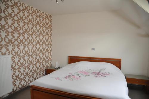 佐内贝克B&B Waterfields的一间卧室配有白色床单和粉红色鲜花。