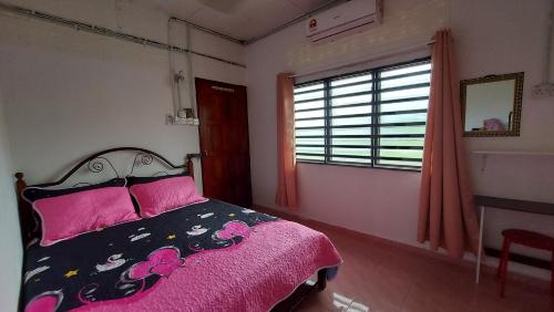 BalingSEROJA HOMESTAY的一间卧室配有一张带粉色床单的床和一扇窗户。
