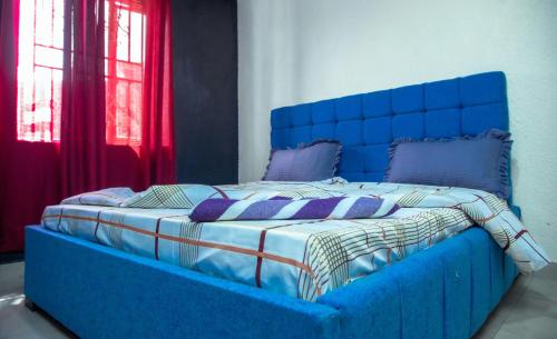 基加利Albina Motel的一张蓝色的床,位于带窗户的房间里