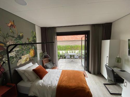 皮滕Gasthuis Sanitatem的酒店客房设有一张床、一张书桌和一个庭院。