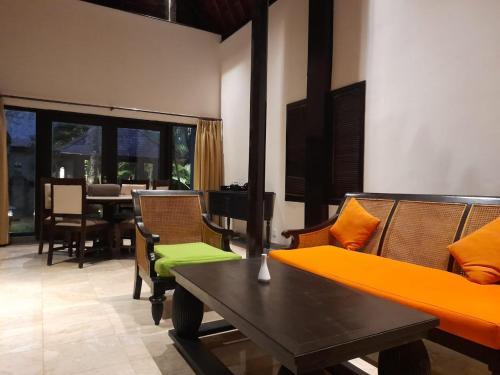 塞米亚克The Royal Beach Seminyak Bali的客厅配有沙发、椅子和桌子