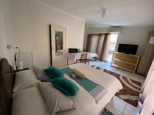 楚梅布El-Kole Bed and Breakfast的卧室配有带绿色枕头的大型白色床