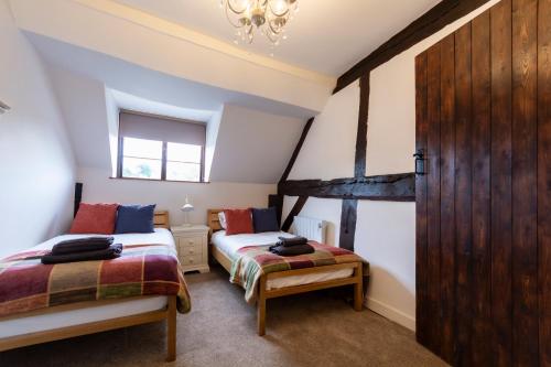 布由德利Bewdley River Cottage - Free private gated parking for 2 cars - River front location的一间卧室设有两张床和窗户。