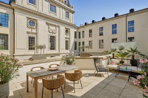 里昂InterContinental Lyon - Hotel Dieu, an IHG Hotel的一个带桌椅的庭院和建筑