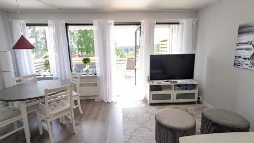 RämshyttanRämsbyns Fritidsby的白色的客厅配有桌子和电视
