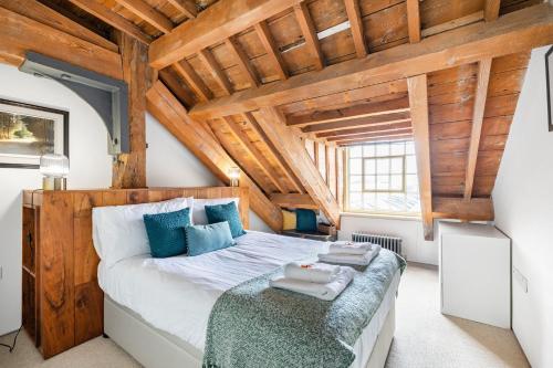 普里茅斯Luxury 2 bed Apartment in historic Royal William Yard的一间卧室设有一张床和木制天花板
