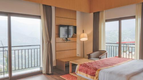 甘托克Days Inn by Wyndham Gangtok Tadong的一间卧室设有一张床、一台电视和窗户。