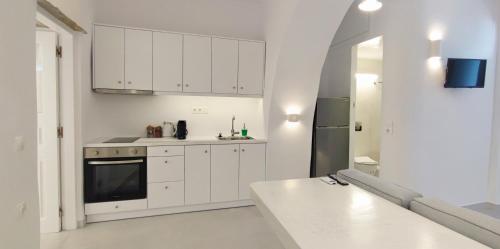 提诺斯Cozy Now的白色的厨房配有白色橱柜和水槽