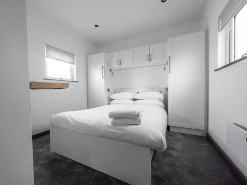 巴里Goodstay Lodges by Urban Space的白色卧室配有一张大白色床和两个枕头
