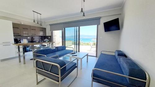 阿莫利亚尼岛Υπόσκαφα cave concept的一间带2张蓝色沙发的客厅和一间厨房