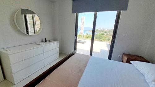阿莫利亚尼岛Υπόσκαφα cave concept的卧室配有大镜子和白色的床