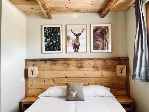 巴多尼奇亚La Maison - Il Riparo del Cervo的卧室配有一张床,墙上有三幅照片