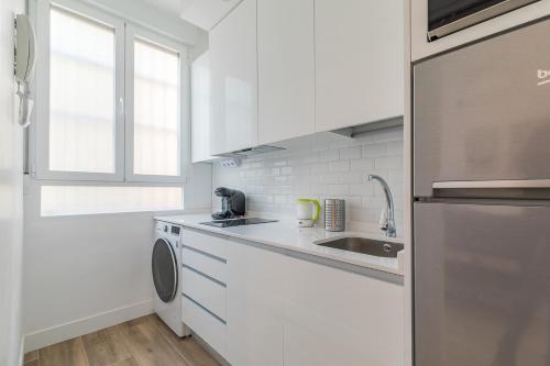 马德里Arturo Soria Apartments3的白色的厨房配有水槽和洗碗机