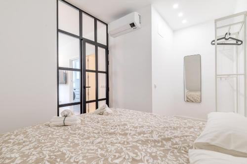 马德里Arturo Soria Apartments3的白色的卧室设有一张大床和一个窗户