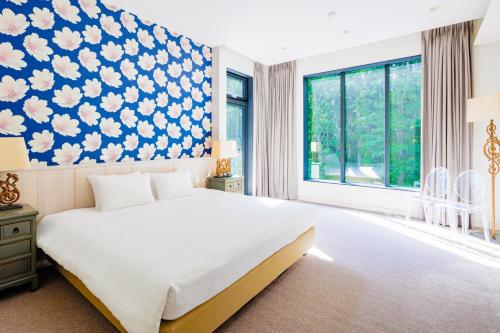 白马村AMO 54 by Hakuba Hotel Group的一间卧室配有一张大床,拥有蓝色和白色的壁纸