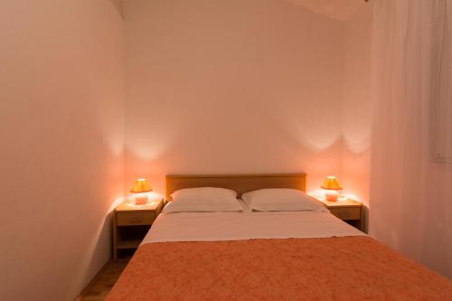 维尼斯切Apartments Mirko的一间卧室配有一张床,两盏台灯放在两张桌子上